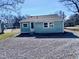 Cozy home with light blue siding, complemented by a gravel backyard and a fenced perimeter at 212 Craig Ave, Henderson, NC 27537