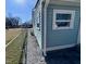 Close-up of light blue vinyl siding, white trim, and a gravel walkway at 212 Craig Ave, Henderson, NC 27537