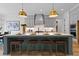 A gourmet kitchen features an island with seating, stylish pendant lights, and modern appliances at 2325 Ballywater Lea Way, Wake Forest, NC 27587