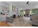 A cozy living room features built-in bookshelves, fireplace, comfortable seating, and access to outdoor patio at 2325 Ballywater Lea Way, Wake Forest, NC 27587