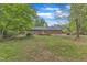 Lush backyard with wooden deck, and partial view of brick house at 2409 Parkway Dr, Raleigh, NC 27603