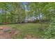 Lush backyard featuring mature trees, a storage shed, and a mix of grassy and mulched areas at 2409 Parkway Dr, Raleigh, NC 27603