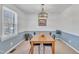 Bright dining room featuring modern lighting, a large window with views of the outdoors, and chair rail details at 2409 Parkway Dr, Raleigh, NC 27603