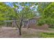Charming brick home with blue shutters and door, set amidst lush greenery and mature trees at 2409 Parkway Dr, Raleigh, NC 27603