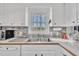 Bright kitchen featuring tile backsplash, stainless steel sink, a window view, and modern appliances at 2409 Parkway Dr, Raleigh, NC 27603