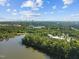 Wide aerial view showing building's exterior, surrounded by trees, near a lake, and a skyline in the distance at 2441 Campus Shore # 402, Raleigh, NC 27606