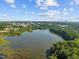 Serene aerial view featuring the building near a lake with lush green trees and skyline in the background at 2441 Campus Shore # 402, Raleigh, NC 27606