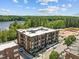 Stunning aerial view of a modern apartment complex near a serene lake and wooded area at 2441 Campus Shore # 402, Raleigh, NC 27606