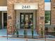 Close-up of building 2441 entrance, featuring brick accents, accessibility ramp, and modern glass doors at 2441 Campus Shore # 402, Raleigh, NC 27606
