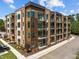 View of a contemporary brick apartment building with modern balconies and well-maintained landscaping at 2441 Campus Shore # 402, Raleigh, NC 27606