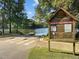 Public fishing area with ramp, sign, and lake access surrounded by trees and grassy areas at 2441 Campus Shore # 402, Raleigh, NC 27606