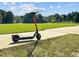 Electric scooter on a paved path with a soccer field in the background at 2441 Campus Shore # 402, Raleigh, NC 27606