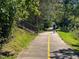 Personal and dog on a sunny walking trail surrounded by lush greenery and stairs to the side at 2441 Campus Shore # 402, Raleigh, NC 27606