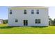Expansive backyard view of the vinyl-sided house with a glass patio door and lush lawn at 261 Hawksmoore Ln, Lillington, NC 27546
