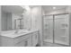 Bathroom featuring dual sinks, quartz countertop, a tiled shower, and modern fixtures at 261 Hawksmoore Ln, Lillington, NC 27546