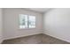 Bright bedroom featuring wood-look floors, neutral walls, and large window at 261 Hawksmoore Ln, Lillington, NC 27546