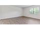 Bedroom features wood-look floors, neutral walls, and large window at 261 Hawksmoore Ln, Lillington, NC 27546