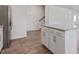 Kitchen island features granite countertops, white cabinets, and is located next to the staircase at 261 Hawksmoore Ln, Lillington, NC 27546