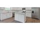 Well-equipped kitchen with stainless steel appliances, a kitchen island, granite counters, and white cabinets at 261 Hawksmoore Ln, Lillington, NC 27546