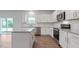 Modern kitchen with stainless steel appliances, granite countertops, white cabinets, and access to the backyard at 261 Hawksmoore Ln, Lillington, NC 27546
