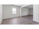 Open living room with wood-look floors, neutral walls, and a large window at 261 Hawksmoore Ln, Lillington, NC 27546