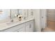 Bathroom showcasing dual sinks with white cabinets and modern fixtures, alongside an open doorway to closet space at 269 Hawksmoore Ln, Lillington, NC 27546