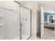 Bathroom with large, glass-enclosed shower showcasing a white, tile surround and modern fixtures with bedroom in background at 269 Hawksmoore Ln, Lillington, NC 27546