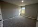 Inviting bedroom with a large window, soft carpeting, and neutral color scheme, creating a cozy atmosphere at 271 Starry Sky Dr, Benson, NC 27504