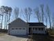 Charming single-story home with attached garage and inviting front porch, set against a backdrop of mature trees at 271 Starry Sky Dr, Benson, NC 27504
