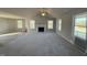Bright living room features fireplace, large windows, plush carpeting, vaulted ceiling, and access to kitchen at 271 Starry Sky Dr, Benson, NC 27504