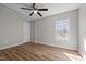 A cozy bedroom with vinyl floors, ceiling fan, neutral paint, and a window at 2810 Hickory Hill Rd, Burlington, NC 27215