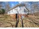 Side of house featuring basement access, brick foundation, and mature landscaping at 2810 Hickory Hill Rd, Burlington, NC 27215