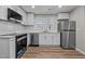Kitchen featuring stainless steel appliances, white cabinets, stone countertops, and stylish backsplash at 2810 Hickory Hill Rd, Burlington, NC 27215