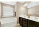 Bright bathroom features a soaking tub under a window and a dual sink vanity with drawers at 3517 Eastern Branch Rd, Raleigh, NC 27610