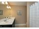 Bathroom featuring double vanity sinks and a shower with white shower curtain at 3517 Eastern Branch Rd, Raleigh, NC 27610