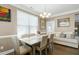 Bright dining room with a wooden table, seating for six, and natural light from large windows at 3517 Eastern Branch Rd, Raleigh, NC 27610