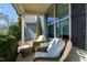 Relaxing front porch featuring comfortable wicker chairs with plush white cushions and a glass-topped table at 3517 Eastern Branch Rd, Raleigh, NC 27610