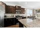 Modern kitchen featuring dark wood cabinets, granite countertops, and stainless steel appliances at 3517 Eastern Branch Rd, Raleigh, NC 27610
