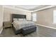 Spacious main bedroom with a tray ceiling, wood floors, and a tufted headboard and bench at 3517 Eastern Branch Rd, Raleigh, NC 27610