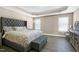 Spacious main bedroom with a tray ceiling, neutral walls, and a large bed and windows at 3517 Eastern Branch Rd, Raleigh, NC 27610