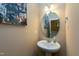 Cozy powder room with a pedestal sink, oval mirror, and neutral wall color at 3517 Eastern Branch Rd, Raleigh, NC 27610