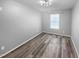 A simple and modern bedroom with gray walls and wood floors and a single window with blinds at 3804 Prince Noah, Wake Forest, NC 27587