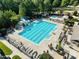 Beautiful aerial view of a luxurious pool with water slide and many lounge chairs with orange umbrellas and tables at 3804 Prince Noah, Wake Forest, NC 27587