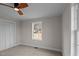 Well-lit bedroom with closet, ceiling fan, carpeted floors, and views through a sunny window at 4459 N Old Carriage Rd, Rocky Mount, NC 27804