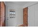 Entryway with brick accent wall, white door with window panes, and hardwood floors at 4459 N Old Carriage Rd, Rocky Mount, NC 27804