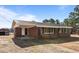 Exterior view of a brick home featuring a covered front porch and well-lit entrance at 4459 N Old Carriage Rd, Rocky Mount, NC 27804