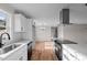 Open kitchen featuring quartz countertops, stainless appliances, white cabinets, and hardwood floors at 4459 N Old Carriage Rd, Rocky Mount, NC 27804