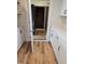 Bright kitchen area showing new white cabinets, laminate flooring and access to storage at 4459 N Old Carriage Rd, Rocky Mount, NC 27804