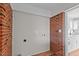 Bright laundry room with brick accent wall and hookups for a washer and dryer, next to kitchen at 4459 N Old Carriage Rd, Rocky Mount, NC 27804