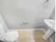 This bathroom features a pedestal sink, a toilet, and neutral tiling at 4820 Landover Arbor Pl, Raleigh, NC 27616
